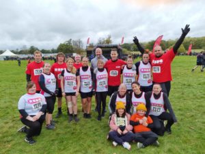 Bootcamp FM are standing outside ready to take on the Winter Wolf Run. They are smiling and wearing RSBC vests. At the front is Stacey, her mum, sister and Teddy.