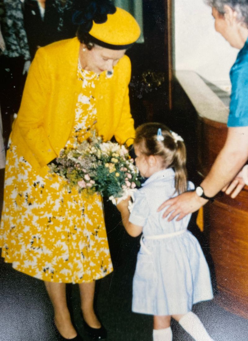 Her Majesty Queen Elisabeth being offered flowers by a girl