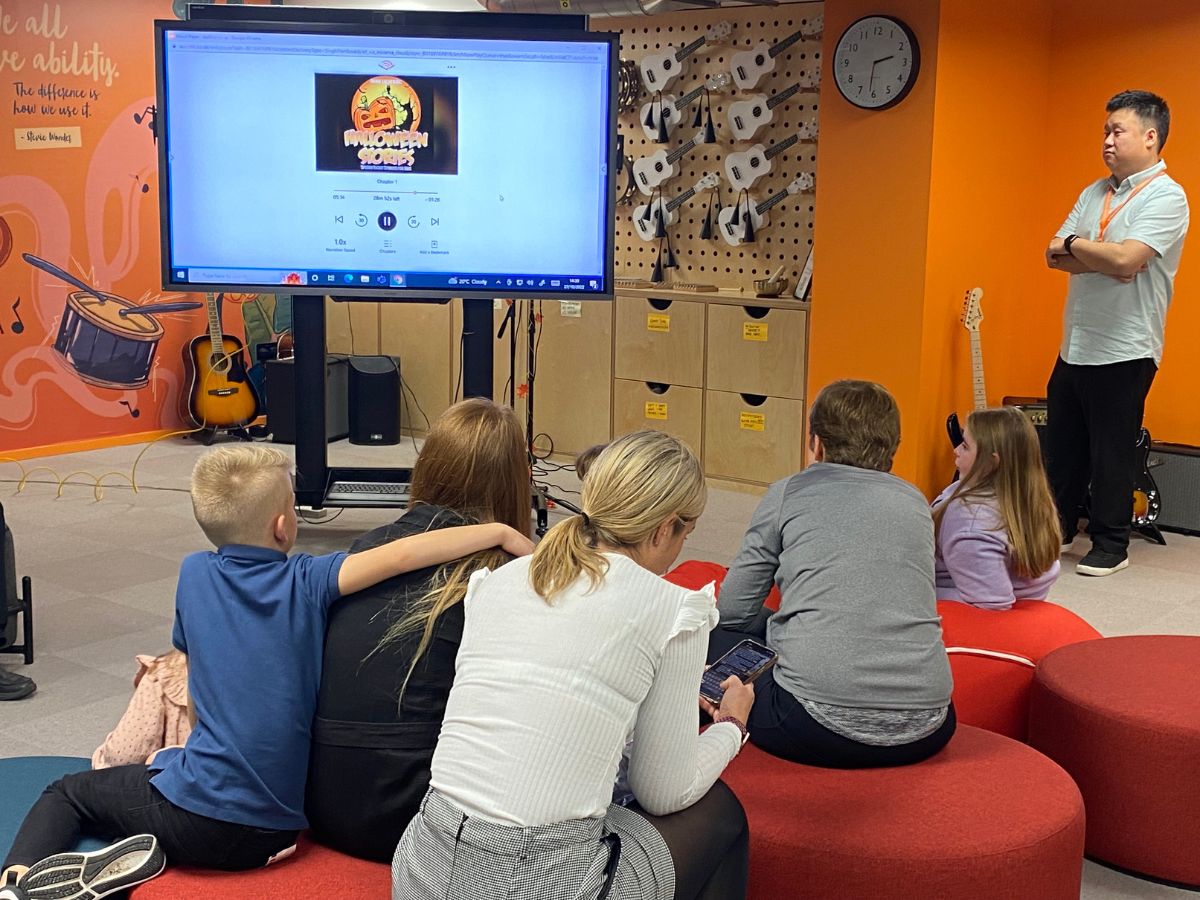 People sitting in front a big screen