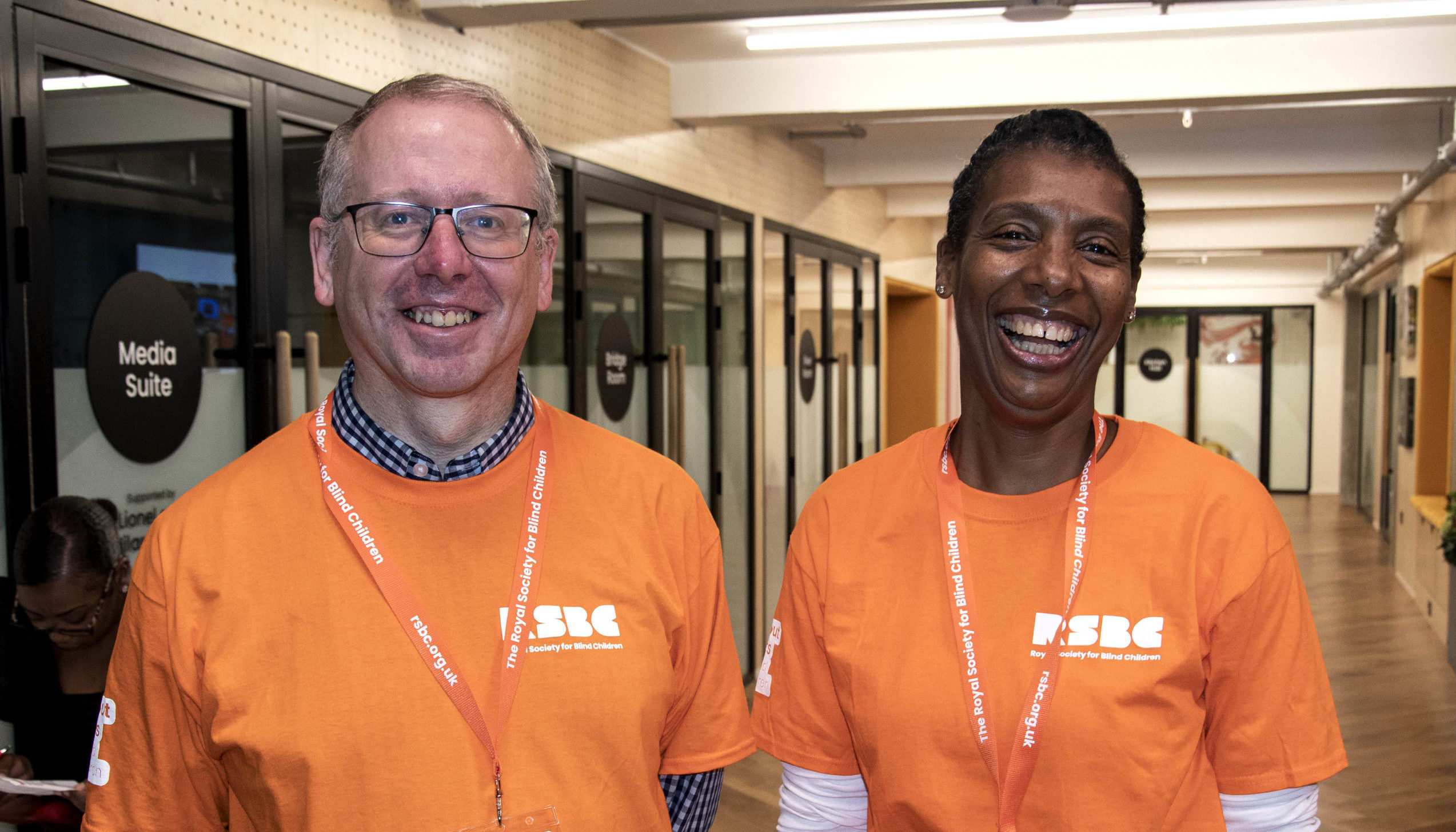 2 people smiling and wearing RSBC volunteer t-shirts