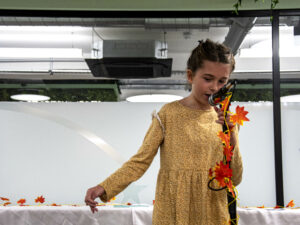 A girl on stage wearing a yellow dress in front of a micro.