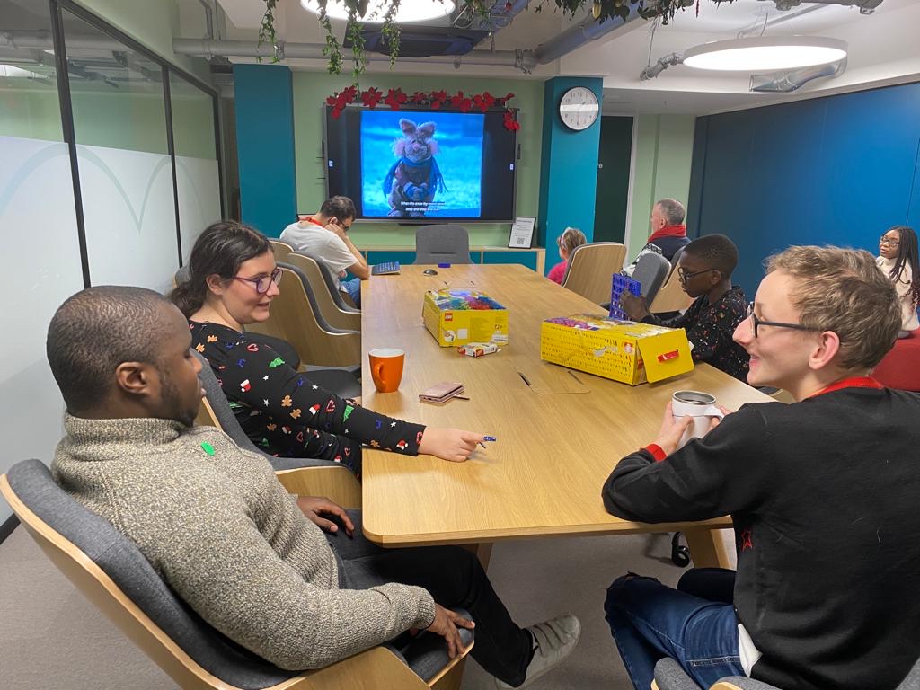 A group of young people seating at a table watching a movie