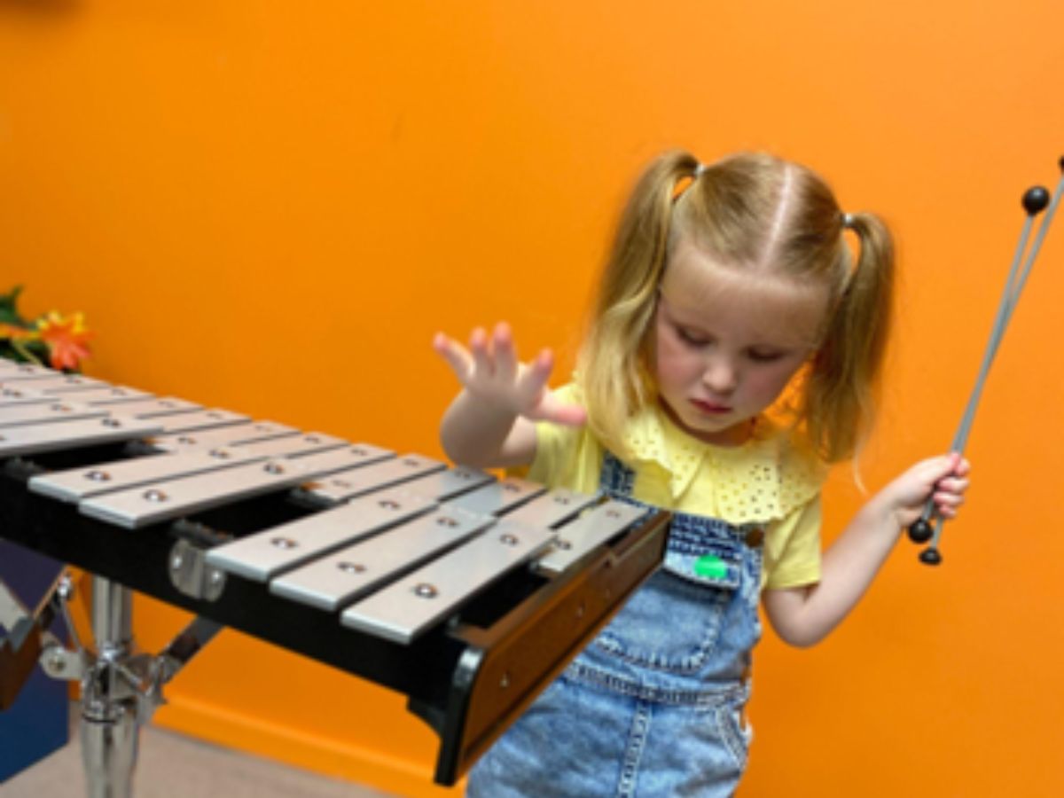 A young vision impaired girl playing xylophone at the RSBC Life Without Limits Centre