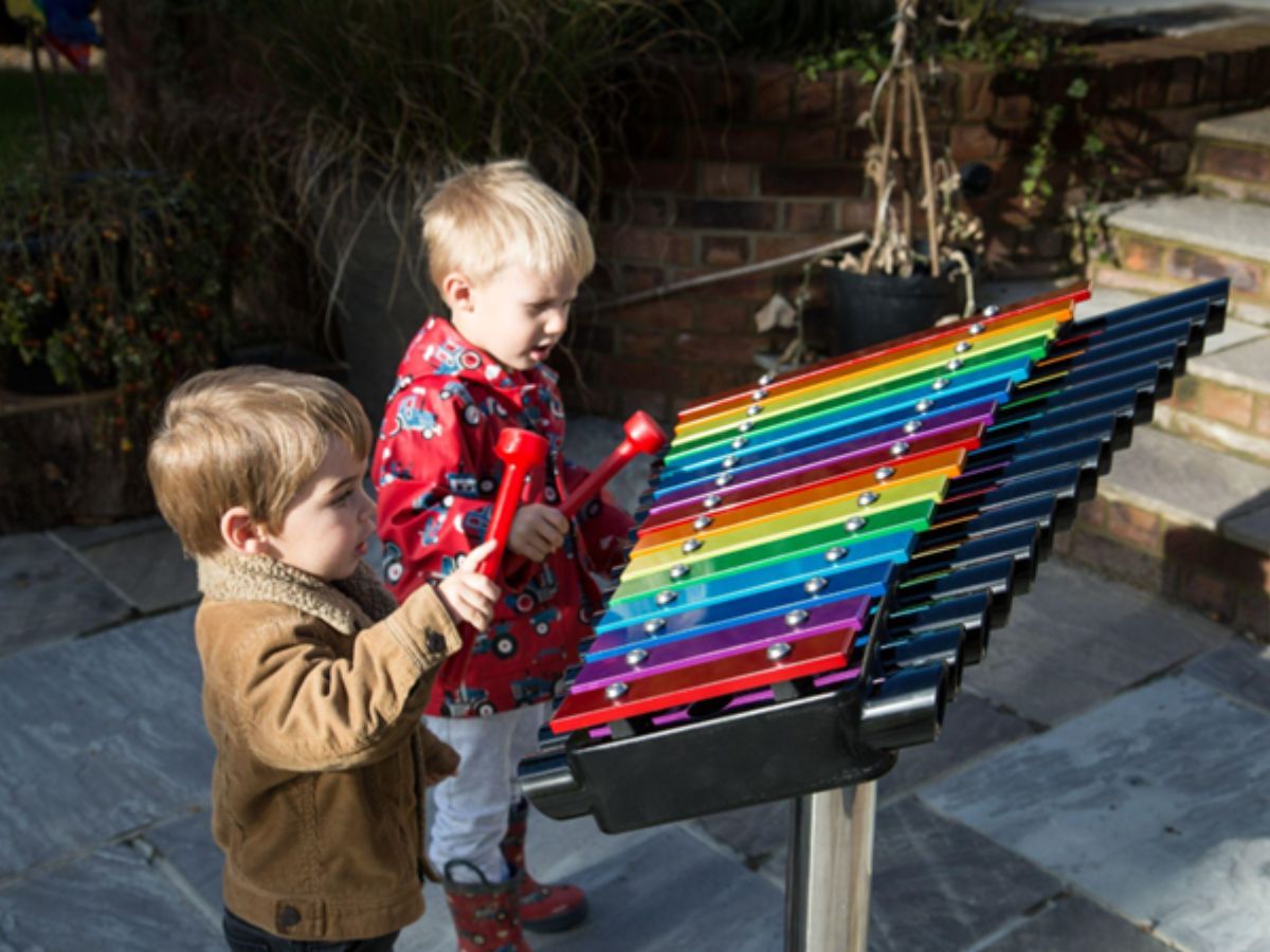 Percussion Play’s colourful xylophone being played outside by 2 children