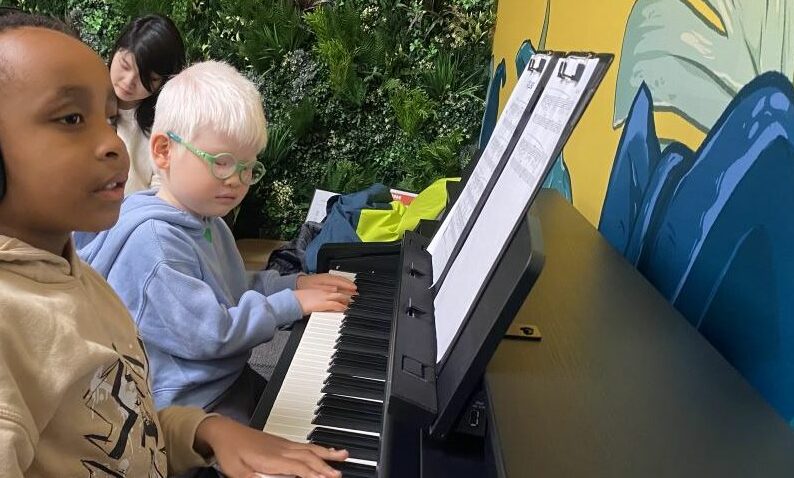 Two vision impaired children playing the piano.