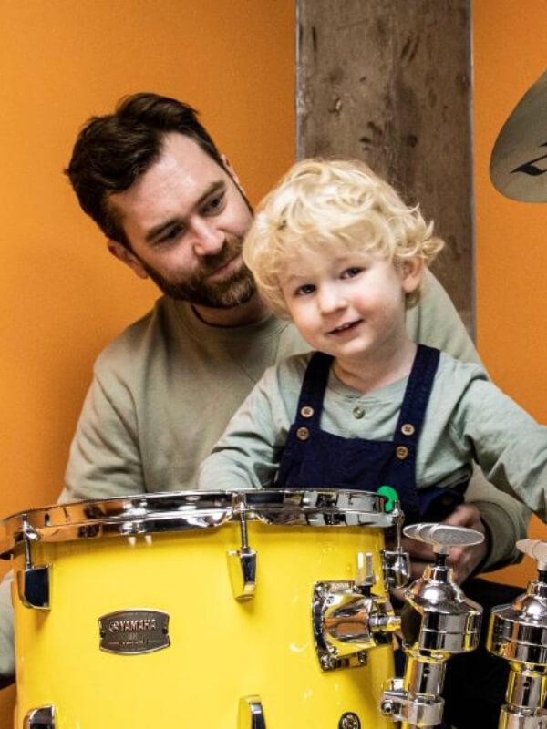 A Dad and his young son, drumming at a Family Fun Day.