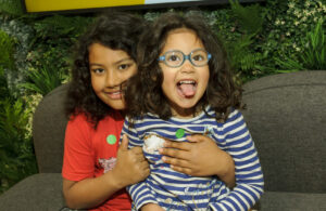 Two young children sitting together, cuddling.