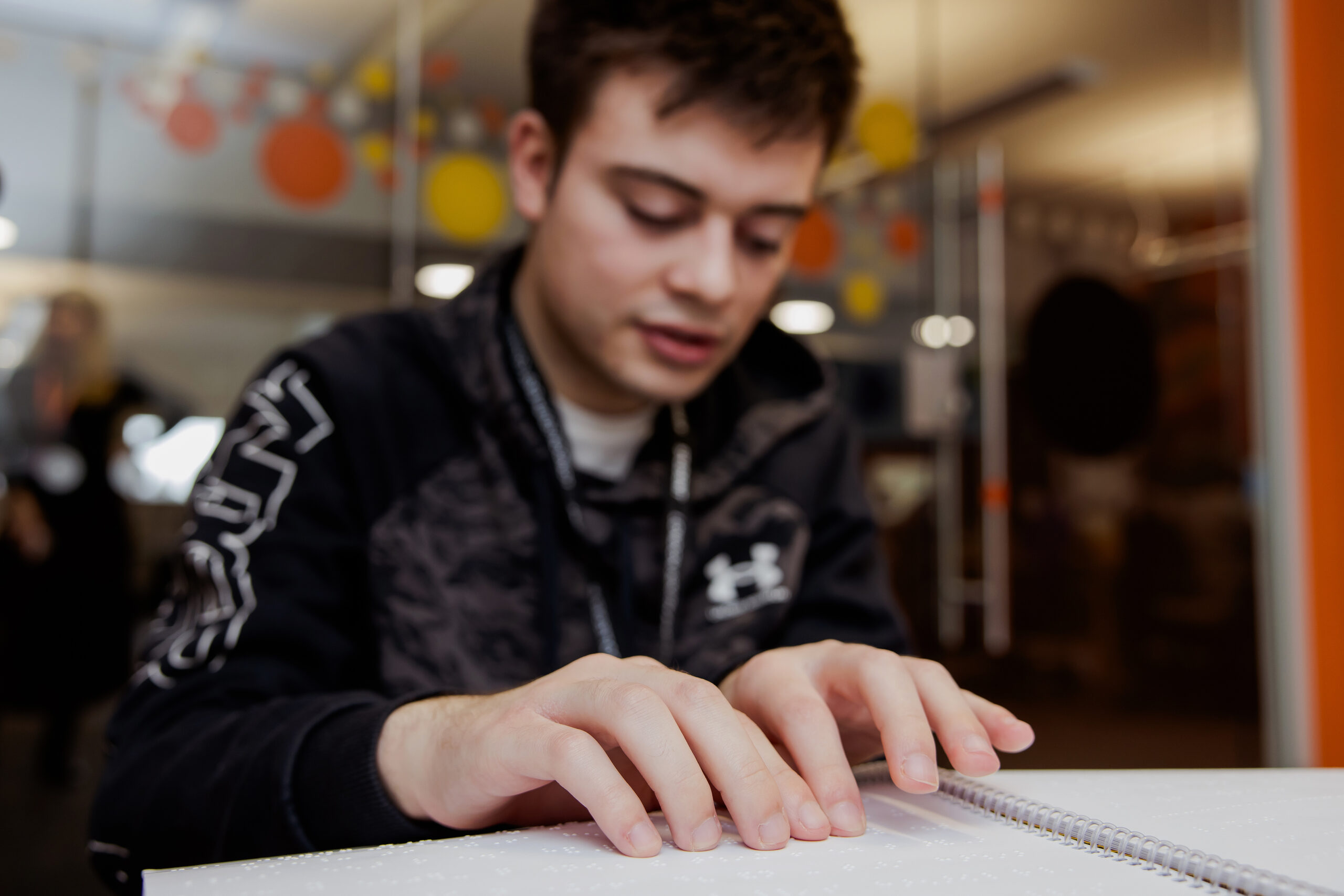 A Dorton College student reading braille.