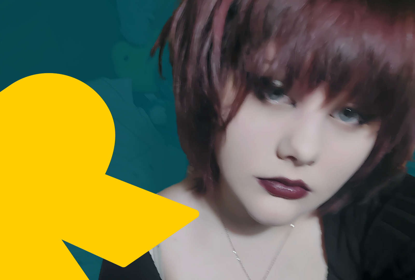 Lauren, a light-skinned young person with short reddish-brown hair and matching lipstick wears a black top and a necklace as they look into the camera with a steady gaze. The background of the image has been edited with a dark navy tint over the image, in the left hand corner there is a graphic yellow RSBC branded 'R'.