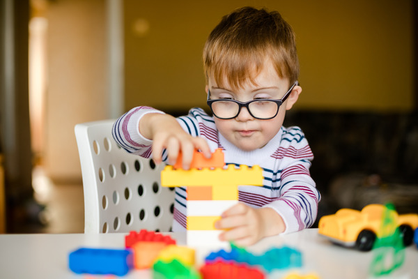 little ginger boy with glasses with playing with colour blocks