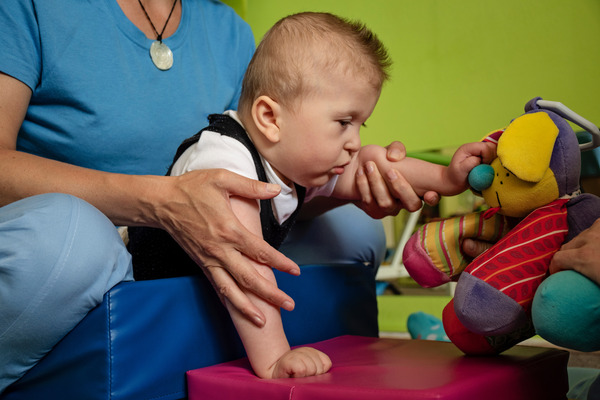 Baby during habilitation therapy session doing exercises.